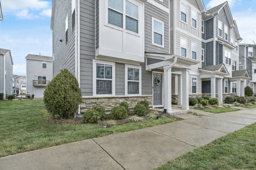 Modern townhomes with covered entries along a residential sidewalk in Brier Creek