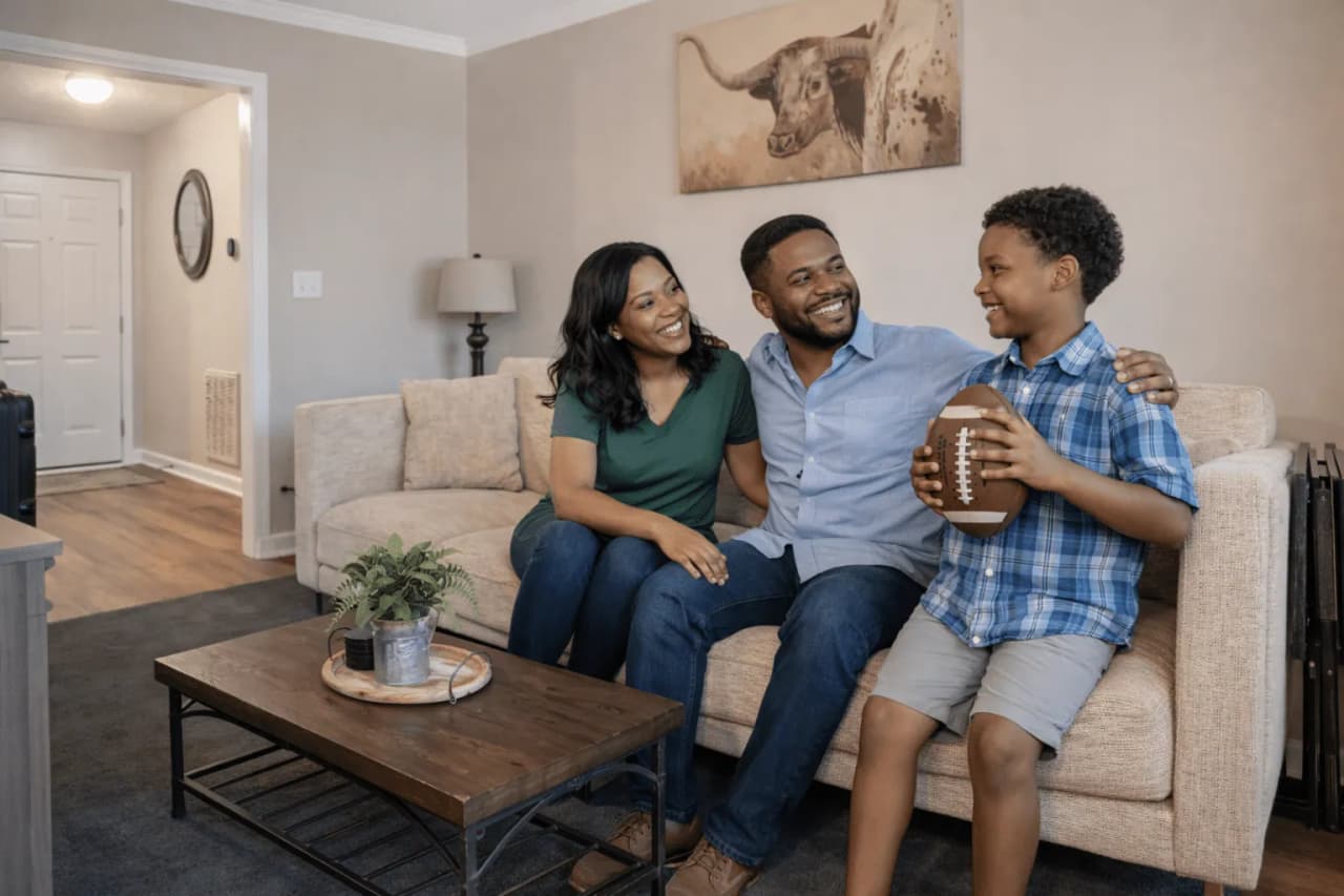 A family relaxing together on the couch of a furnished rental
