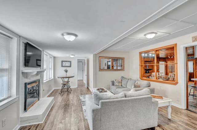 Open-plan living room with gray sofas and a fireplace in a CFR home